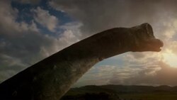 A herd of large dinosaurs trek across an open plain. Stock Footage