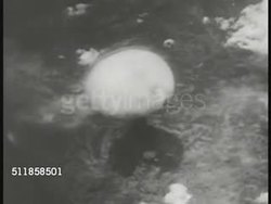 1945: NAGASAKI, JAPAN: AERIAL: TD Atomic bomb exploding on ground, cloud climbing. WS Mushroom cloud top. Nuclear weapon, end of WWII. Instructional Video