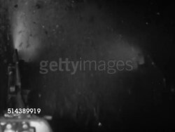 1952: COAL MINING:  VS Coal miners operating coal cutter, machine cutting into soft coal wall (the Pittsburgh Coal Seam), machine digging into coal pieces, moving pieces onto moving conveyor belt, leading outdoors. Steel industry, coal bed, bedrock Instructional Video