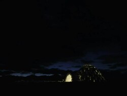 MS T/L Day last light fading away over a mountain vista with an igloo on ground,Candle light remains on in Igloo and switches off towards end With cloud movement / Bohinj, Triglav, Slovenia Stock Footage