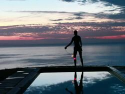 WS Woman doing poi dance with neon balls beside pool at sunrise / Montezuma, Costa Rica Stock Footage