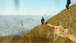 two backpacker men walking down from high slope of mountain Stock Footage