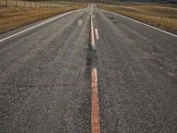 POV of empty Highway with dramatic clouds on prairie and sun moving across landscape with pan down. and up. Stock Footage