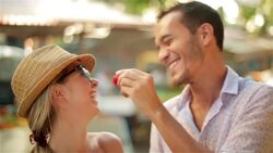 Cute young couple share a strawberry at Brazilian outdoor market Stock Footage
