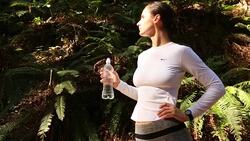 A young women running, working out, stretching and checking her mobile device outdoors on a sunny day. Stock Footage