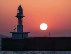 MS T/L Shot o Lighthouse by ocean at sunrise / Sokcho, Gangwondo, South Korea Stock Footage