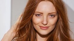 Woman touches her red hair then rolls her head to the right Stock Footage