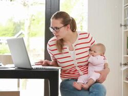 Mother holding baby working from home on phone Stock Footage