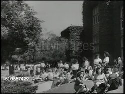 1950: US CAMPUS: Dam w/ flowing water. VS College students on campus grounds, sitting in shade w/ ivy covered walls BG & in sunlight talking, girls standing, talking w/ notebooks. Young adult women sitting on campus grass. Instructional Video
