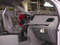 MS Worker using lift arm to install driver seat in minivan at an auto assembly plant / Princeton, Indiana, United States Stock Footage