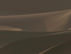 Medium pan-left - Pristine sand dunes cast shadows in the Sahara Desert / Sahara Desert, Egypt Stock Footage