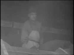 Men unload boxes and bags of food from a military airplane during Project Vittles. News Clip