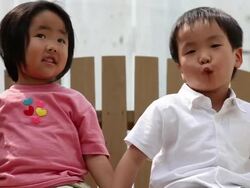 Close up of boy and girl infants on the swing holding their hands Stock Footage