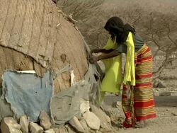 Woman fixing straw on hut Stock Footage