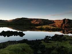 MS Reflective lake in late afternoon light surrounded by volcanic rock / Reykjavik, Borgarfjaroarsysla, Iceland Stock Footage