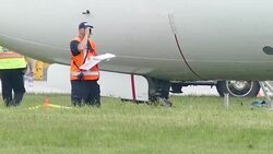 Investigator searching for clues on airplane's collapsed gear Stock Footage