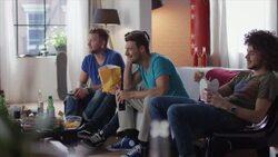 Guys sitting on couch watching funny movie Stock Footage