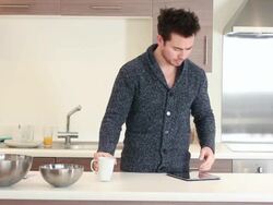 male in kitchen drinking and working on laptop Stock Footage