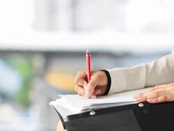 HD DOLLY:Hand of business woman writing on paper in a binder. Stock Footage