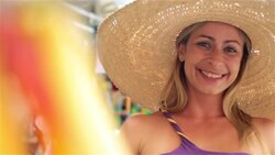 Brazilian woman wearing sombrero smiles and laughs at camera in Rio marketplace Stock Footage