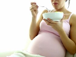 Pregnant woman relaxing at home and eating salad snack. Stock Footage