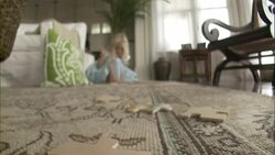 A spider sits on a puzzle piece near a little girl who plays on the floor. Stock Footage