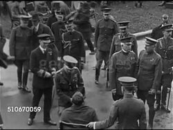 1920s: ROYAL VISIT: Edward in uniform, Prince of Wales w/ entourage of officers, soldiers, cameramen w/ tripods visiting injured WWI soldiers in wheelchairs, VS Edward speaking to, shaking hands with soldiers.  United Kingdom, British Dominion, Colony Instructional Video