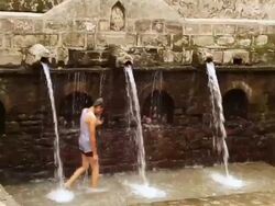 WS ZI Boy standing under fountain of Sitabani Temple at Jim Corbett National Park  / Nainital, Uttarakand, India Stock Footage