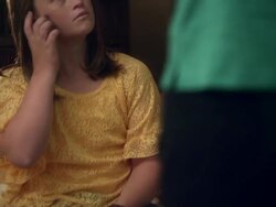 Slow motion of down syndrome girl sitting on bed running fingers through her hair. Stock Footage