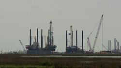 Oil rigs operate offshore in Grand Isle, Louisiana. Stock Footage