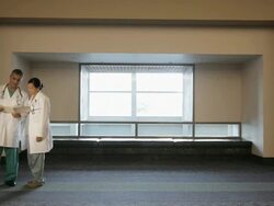 WS Two physicians in scrubs entering, shake hands and looking over medical chart / Seattle, Washington, USA Stock Footage