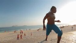 Brazilian capoeira artist jumps, shakes dreadlocks and roars on Ipanema boardwalk Stock Footage