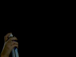 High Speed Aerosol, hand holding can, sprays fine white mist into air against black background Stock Footage