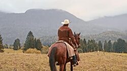 SLO MO Cowboy riding his horse across countryside Stock Footage