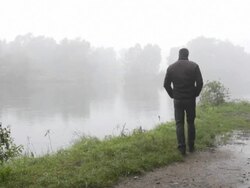 Man walking on river side in autumn at morning Stock Footage