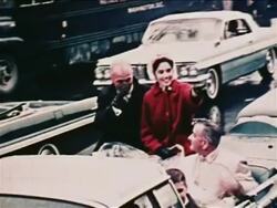 1962 John Glenn + wife pointing + riding in convertible with Lyndon Johnson in parade / newsreel Stock Footage