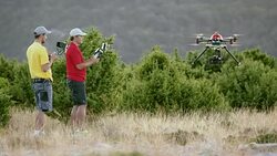 LD Two operators successfully landing a drone on hilltop Stock Footage