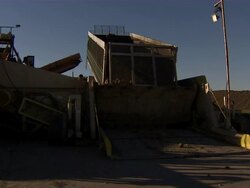 Pan from trailer emptying sugar beets to employee operating the machinery from a box on top of some stairs. Stock Footage