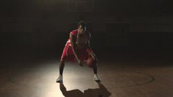A determined basketball player performs dribbling techniques at center court of a gym. Stock Footage