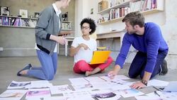 Creative business people reviewing and discussing proofs on office floor Stock Footage