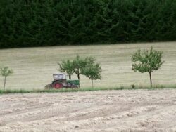 WS Tractor passing through grass field / Serrig, Rhineland-Palatinate, Germany Stock Footage