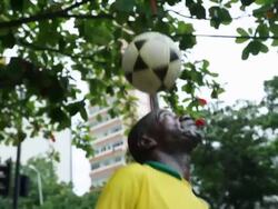  MS TS TU Shot of coloured guy with brazilian trikot playing freestyle football at street corner, total shot at a street corner, close up / Rio de Janeiro, Brazil  Stock Footage