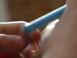 Young girl playing with colourful loom bands News Clip