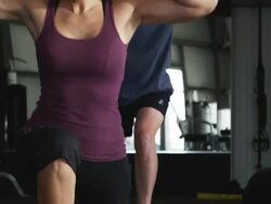 man and a woman doing squats in a gym Stock Footage