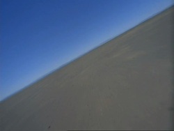 Tracking at low angle over expanse of wet sand, South Africa Stock Footage