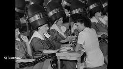 1945: BEAUTY SALON: HD: Woman having manicure while sitting under hairdryer, woman under dryer reading magazine, CU magazine article 'Now that he's home', WS Women under dryers. Instructional Video