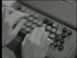 Hands type on a punch card machine. News Clip