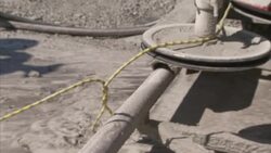 A quarry worker adjusts the slack on a granite cutter cable. Stock Footage