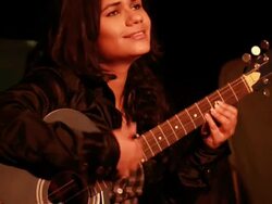 Young woman playing guitar in the forest, Delhi, India Stock Footage