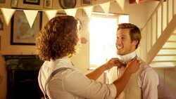 Groomsman helping groom with bowtie before wedding Stock Footage